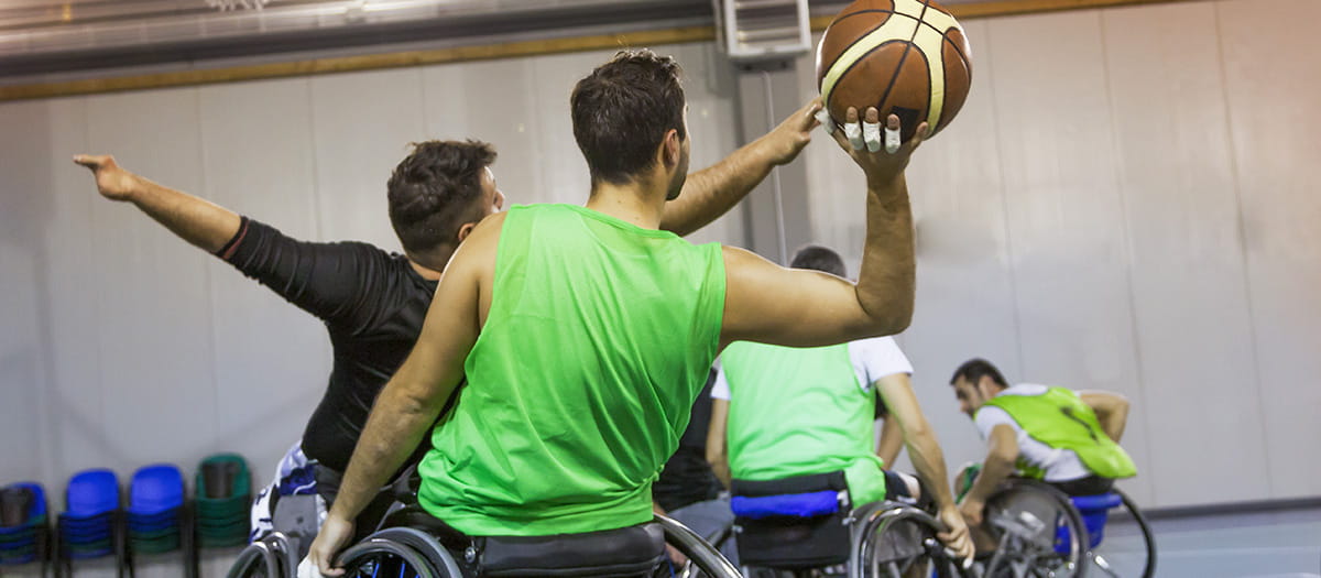 Four men in wheelchairs playing indoor wheelchair basketball