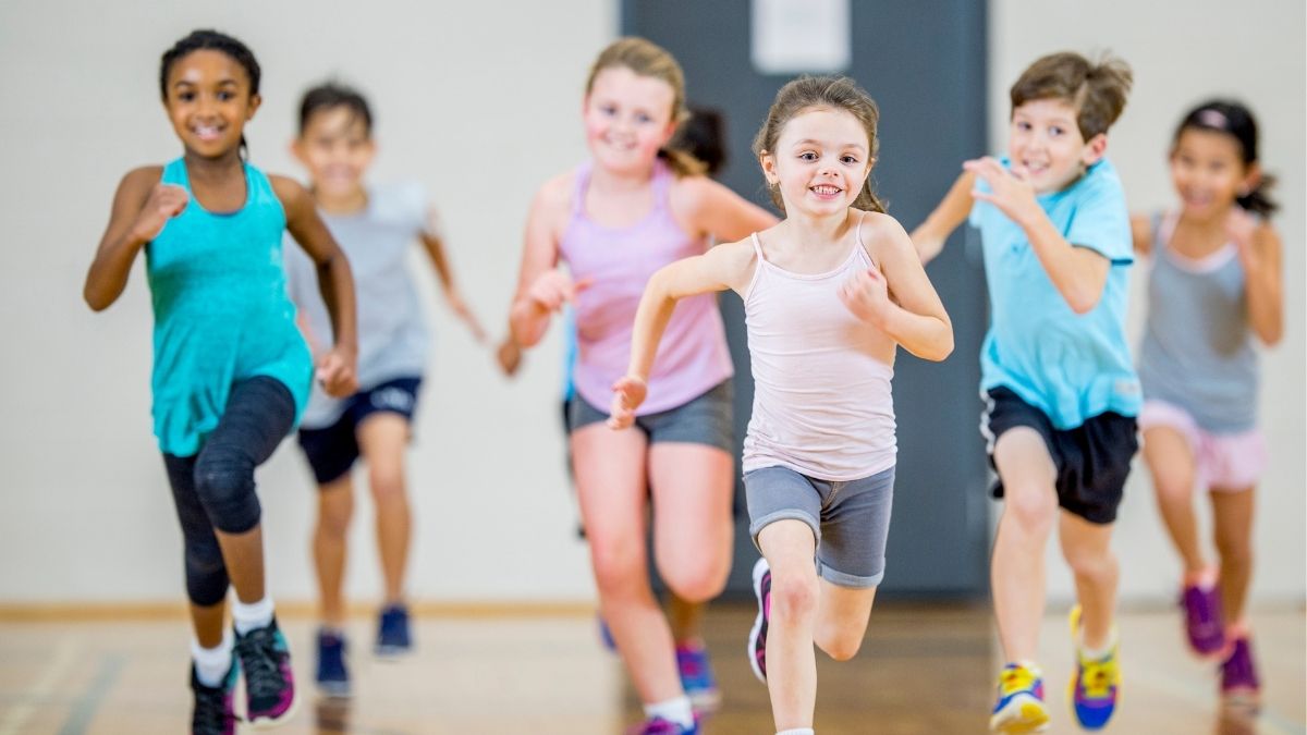 Group of children running inside a gymnasium