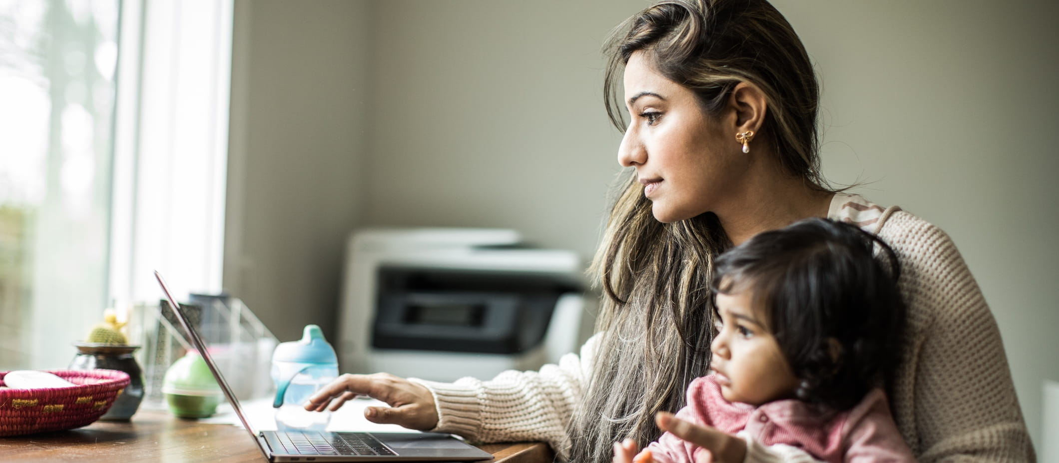 mother sitting with young child looking on a computer