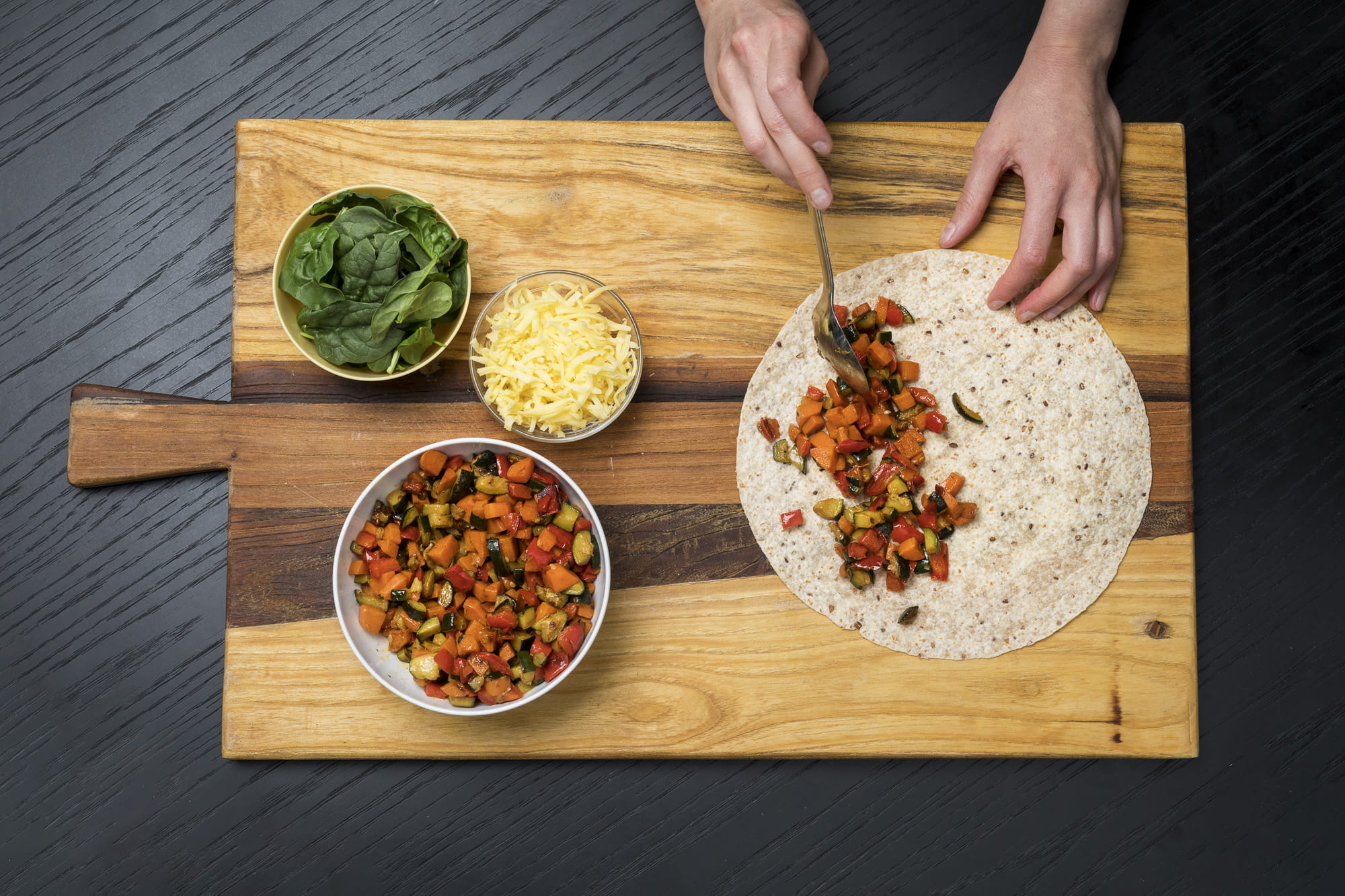 Image of vegetables being spooned onto tortilla