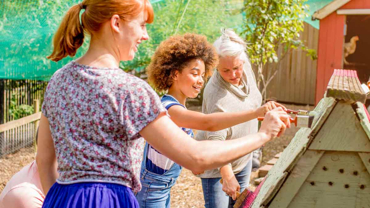 Group of women painting chicken coop