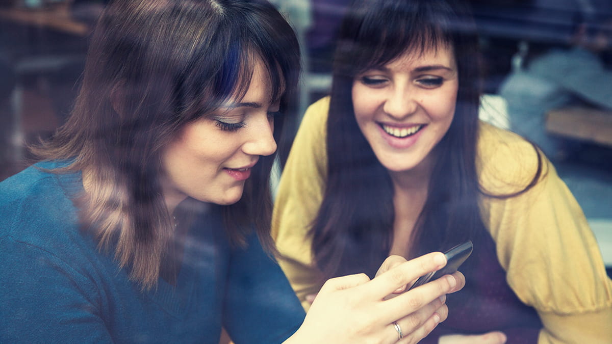 Two young women looking at a smartphone