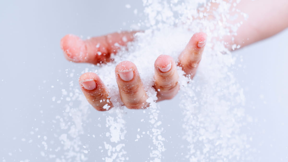 Close-up of hand with salt falling through