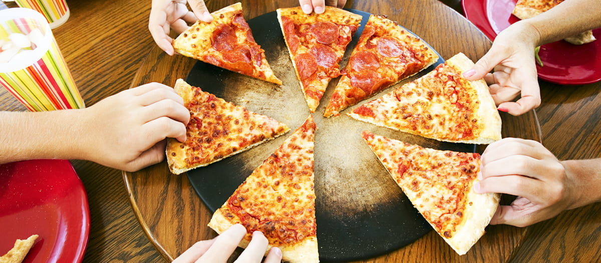 Hands grabbing pizza