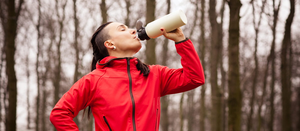 Woman runner drinking from a water bottle