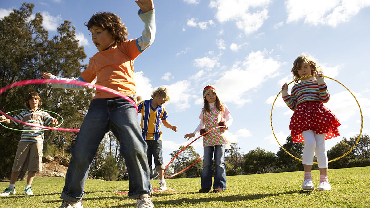 Children playing with hula hoops in a park