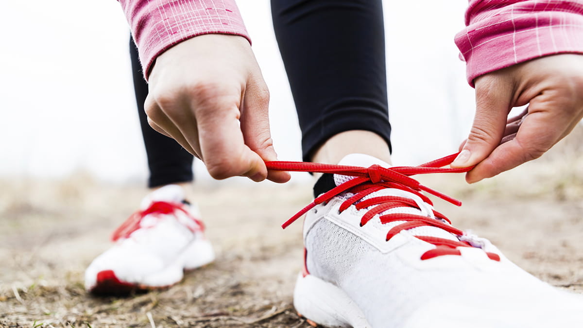 A woman tying her running shoe laces