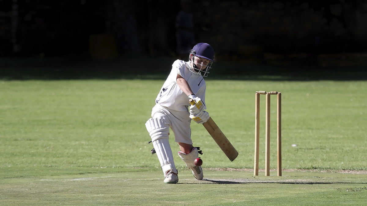 Young boy playing cricket for a club
