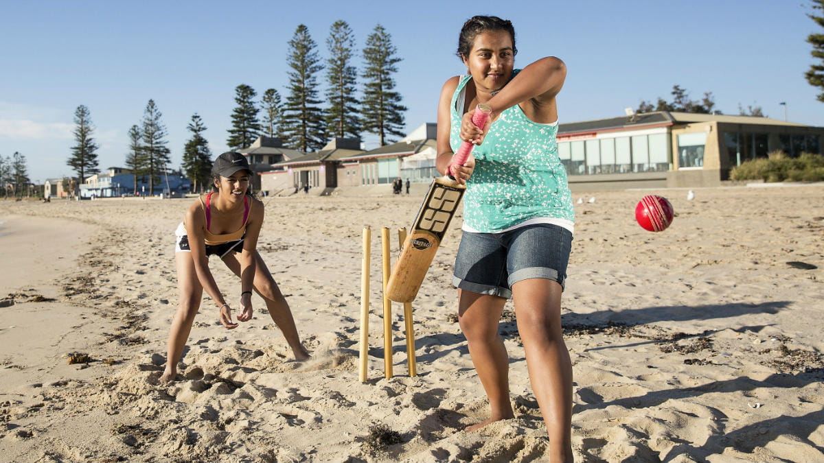 Woman playing cricket on the beach