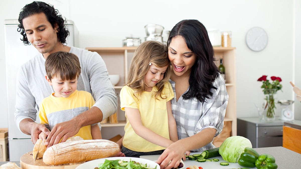 Parents cooking healthy food with their children