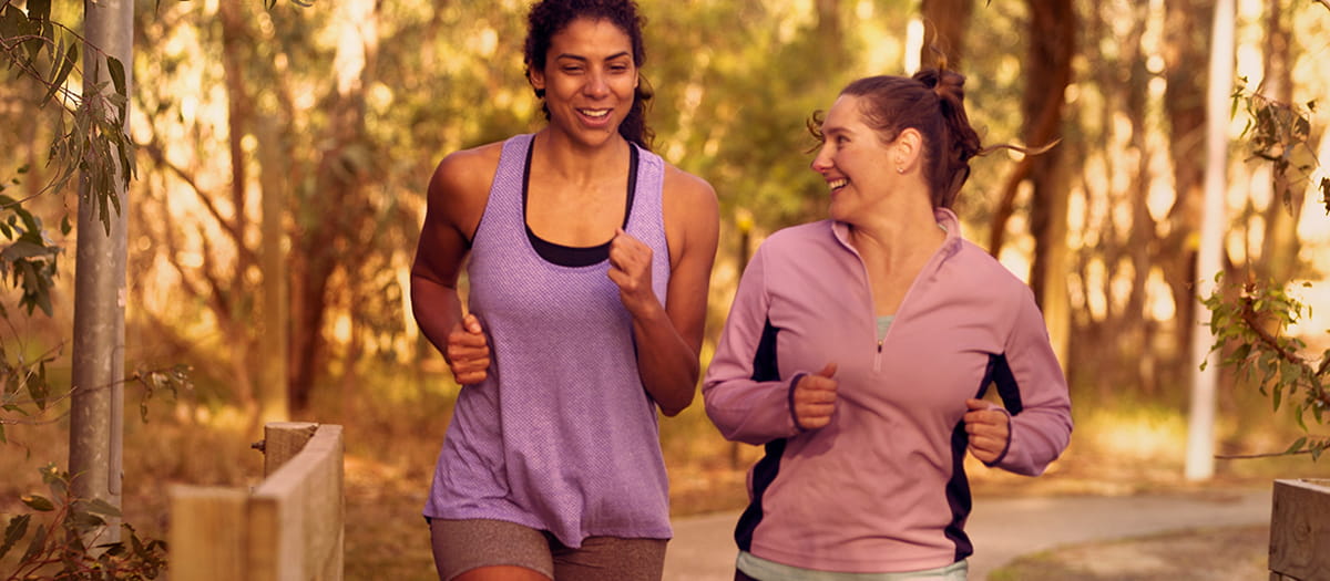Two women running together in a park