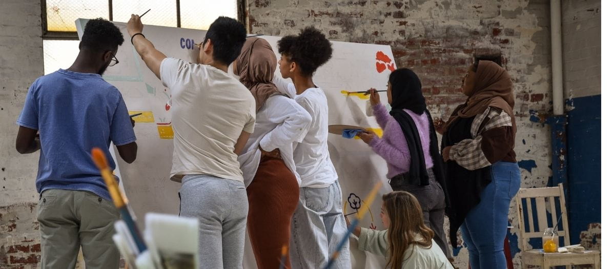 Group of young people painting a mural