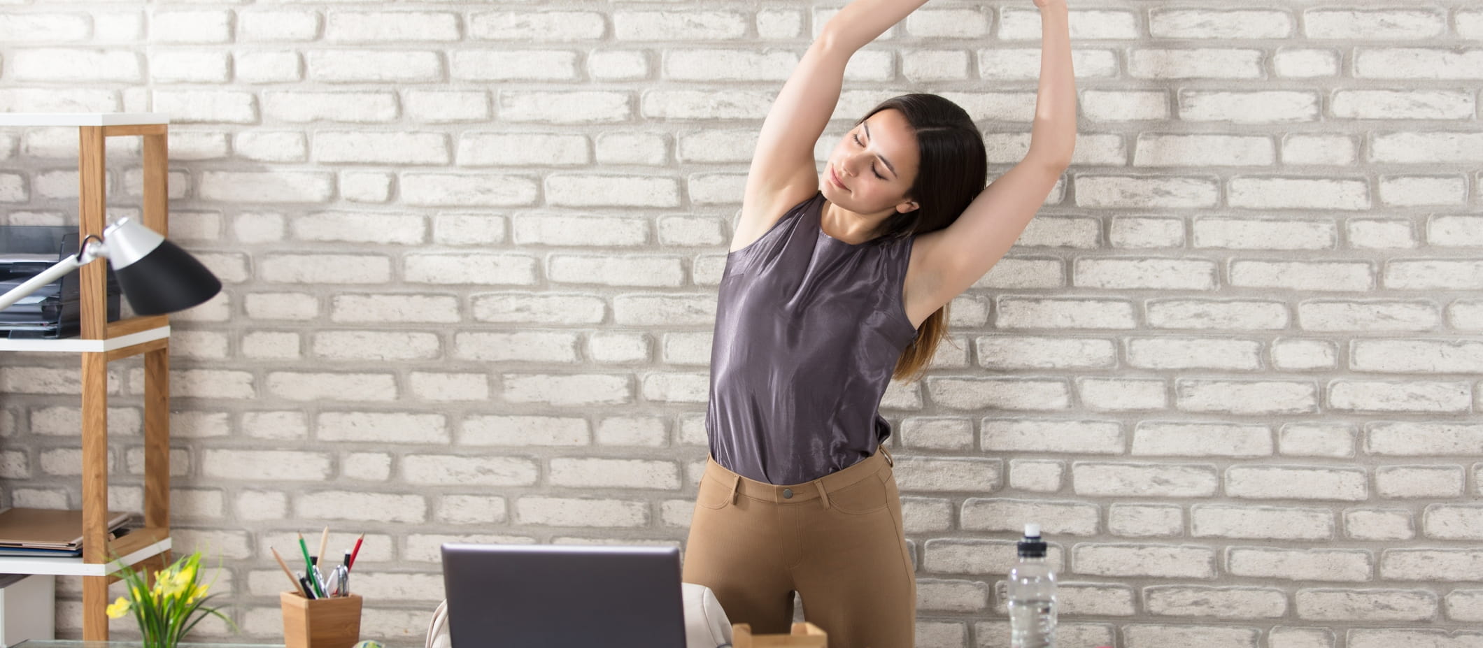 female worker stretching at desk 