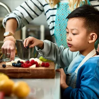 Food-young child and parent preparing food in kitchen