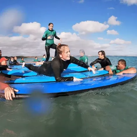 A group of STOKED Surf Therapy participants on surfboards in the ocean