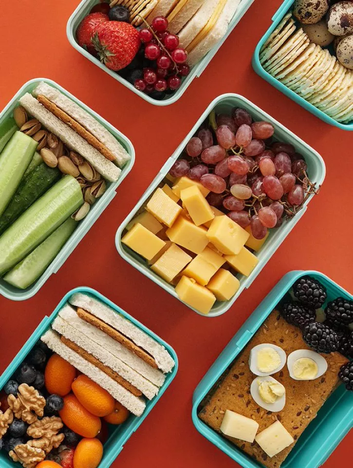 Kids healthy lunch boxes with fruit, vegetables, dairy and grains.