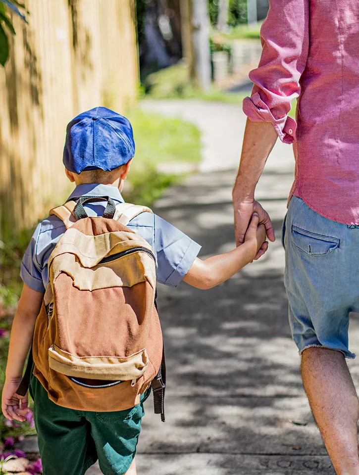 A photo of a school child holding hands with a parent